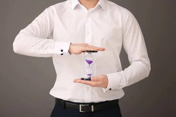 Man håller timglas på grå bakgrund. Time management koncept — Stockfoto