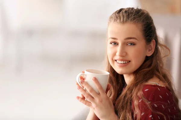 Young woman drinking tea on blurred background — Stock Photo, Image