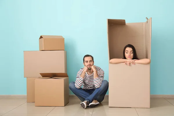 Mladý pár si hraje s obrovským box uvnitř. Stěhování do nového domu — Stock fotografie