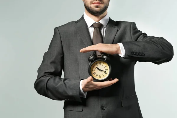 Ο άνθρωπος που κρατά ρολόι σε γκρι φόντο. Αντίληψη της διαχείρισης του χρόνου — Φωτογραφία Αρχείου