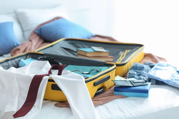 ベッドの上に服を着てオープン旅行スーツケース — ストック写真