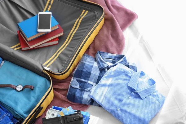 Open travel walizkę z ubrania na łóżku — Zdjęcie stockowe