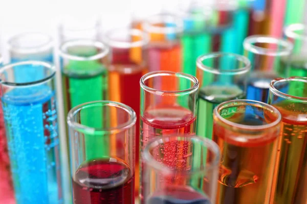 Beaucoup de tubes à essai avec des liquides colorés, gros plan — Photo