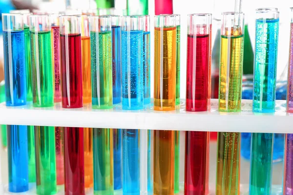 Muchos tubos de ensayo con líquidos de colores, primer plano — Foto de Stock