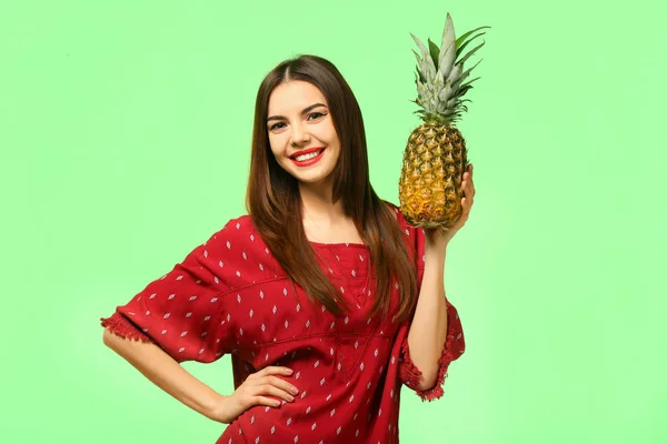 Attractive young woman with pineapple on color background — Stock Photo, Image