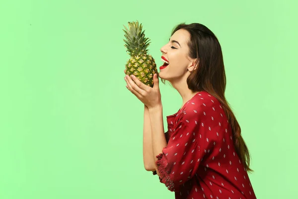 Attraente giovane donna con ananas su sfondo di colore — Foto Stock