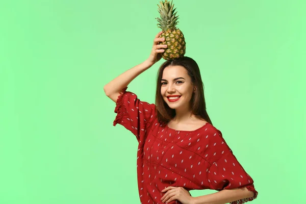 Attractive young woman with pineapple on color background — Stock Photo, Image