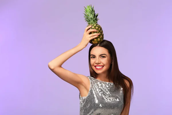 Attractive young woman with pineapple on color background — Stock Photo, Image