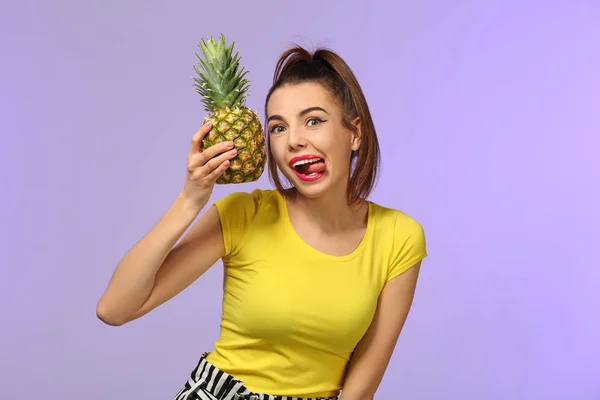 Emotional young woman with pineapple on color background — Stock Photo, Image