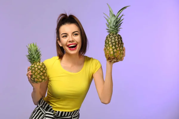 Atrakcyjna, młoda kobieta z dwoma ananasy na kolor tła — Zdjęcie stockowe