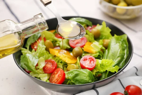 Одевание свежего овощного салата с оливковым маслом — стоковое фото