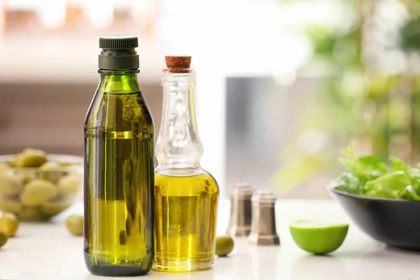 Botellas con aceite de oliva en la mesa — Foto de Stock