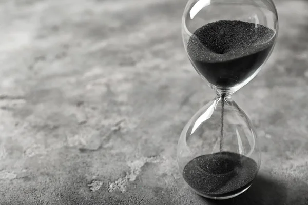 灰色の背景上に砂時計。時間管理の概念 — ストック写真