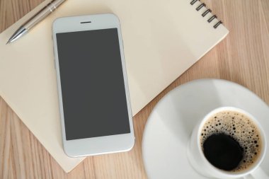 Ahşap masa üstünde defter ile modern cep telefonu. Online yemek teslim kavramı