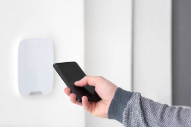 Ayar alarm sistemi ile hareket eden telefon, kapalı genç adam