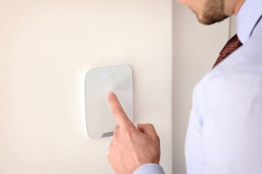 Genç adam güvenlik alarm sistemi üzerinde kapalı kodunu girme