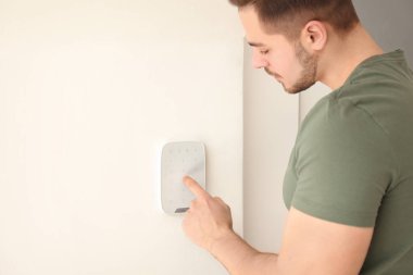 Genç adam güvenlik alarm sistemi üzerinde kapalı kodunu girme