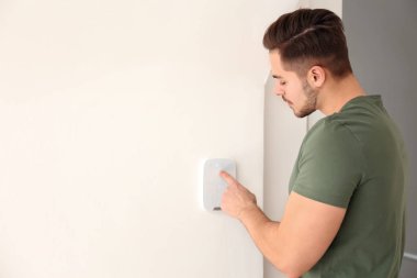 Genç adam güvenlik alarm sistemi üzerinde kapalı kodunu girme