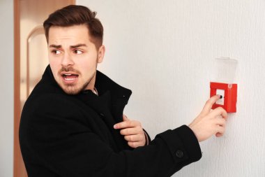 Genç adam yangın alarm sistemi, kapalı düğmeye