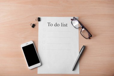 Ahşap arka plan üzerinde telefon ile boş yapılacaklar listesi