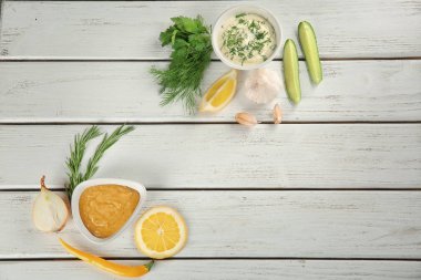 Beyaz ahşap arka plan, üstten görünüm üzerinde farklı sos ile kompozisyon