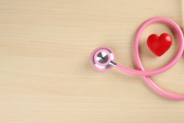 Ahşap arka plan üzerinde küçük kalbi steteskop