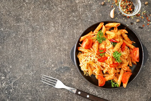 Frigideira com saborosa massa penne no fundo cinza — Fotografia de Stock