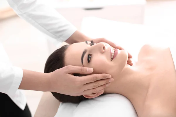 Mujer joven disfrutando de masajes faciales en el salón de spa — Foto de Stock