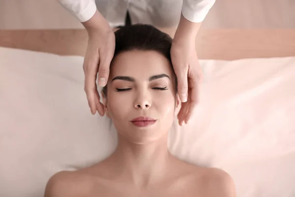 Mujer joven disfrutando de masajes faciales en el salón de spa —  Fotos de Stock