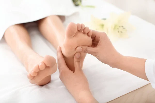 Mladá žena se těší masáž chodidel ve spa salonu, zaměření na nohy — Stock fotografie