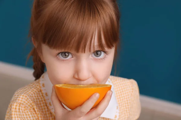 Cute little girl eating citrus fruit at home, closeup — Stock Photo, Image