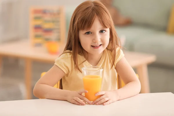 Śmieszne, mała dziewczynka z soku cytrynowym w domu — Zdjęcie stockowe