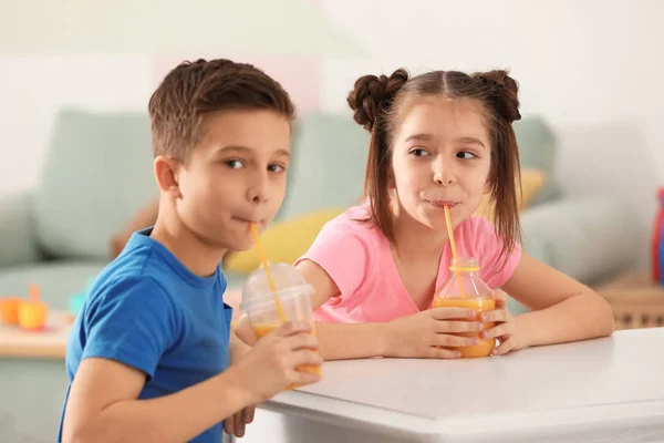 Funny little children drinking citrus juice at home — Stock Photo, Image