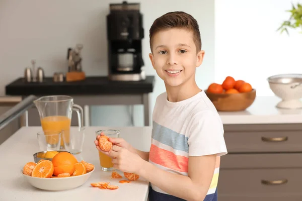 Funny little boy eating citrus fruit at home — Stock Photo, Image