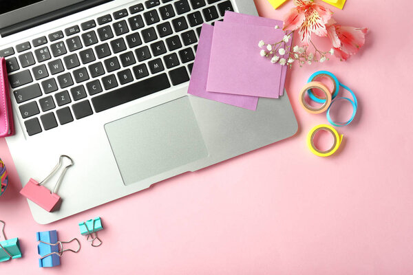 Ноутбук и канцелярские принадлежности на цветном фоне, плоский уголок. Состав рабочего стола
