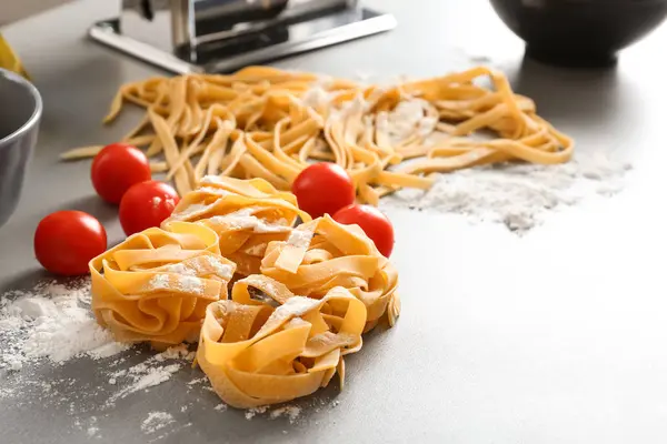 Rohe Nudeln und Kirschtomaten auf dem Tisch — Stockfoto