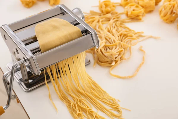 Metal pasta maker with dough on white background — Stock Photo, Image