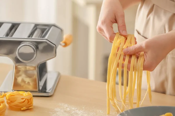 Frau bereitet Pasta am Tisch zu — Stockfoto