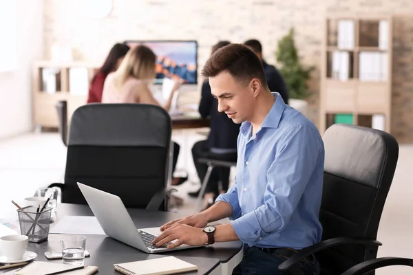 Молодий чоловік використовує ноутбук, щоб підготуватися до ділової зустрічі в офісі — стокове фото