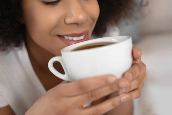 Mulher afro-americana bonita bebendo chá dentro de casa, close-up — Fotografia de Stock