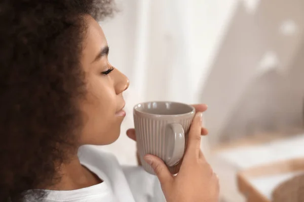 Beautiful African-American woman drinking tea indoors — Stock Photo, Image