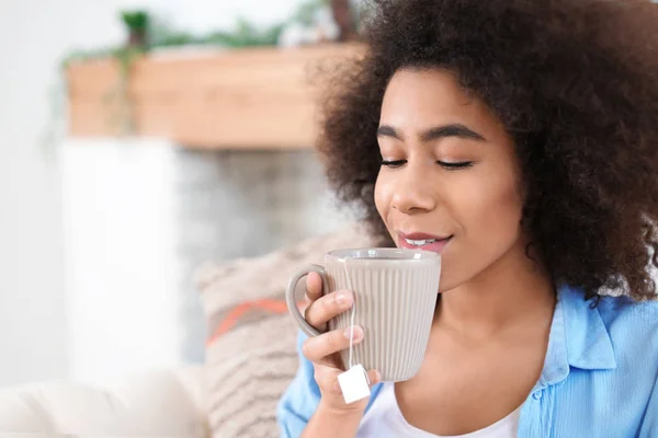 Beautiful African-American woman drinking tea at home — Stock Photo, Image