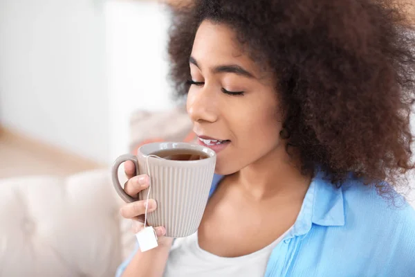 Beautiful African-American woman drinking tea at home — Stock Photo, Image