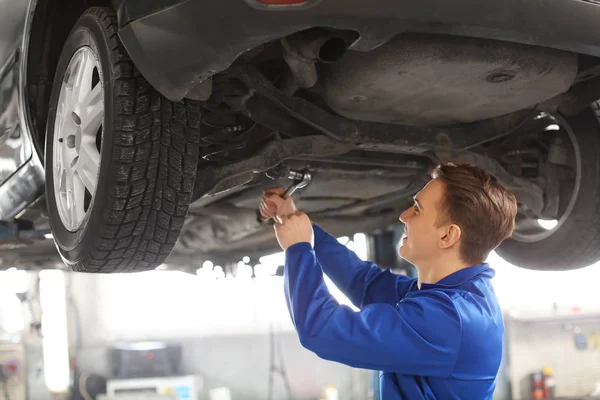 Mechanik mężczyzna naprawianie samochodu w centrum obsługi — Zdjęcie stockowe