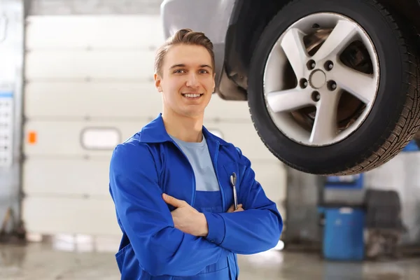 Portrait of male mechanic near car in service center — Stock Photo, Image