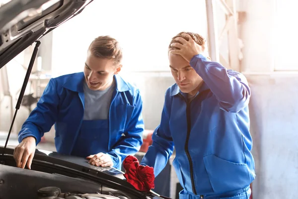 Mecánica masculina que fija el coche en el centro de servicio — Foto de Stock