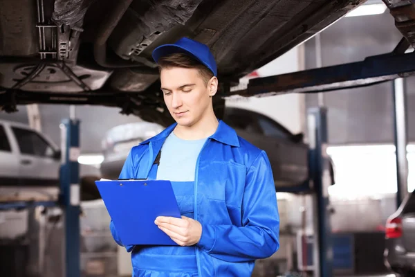 Mužské mechanik s schránky zkoumání auto v servise — Stock fotografie