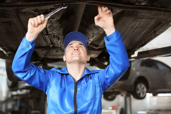 Mecânico masculino fixando carro no centro de serviço — Fotografia de Stock