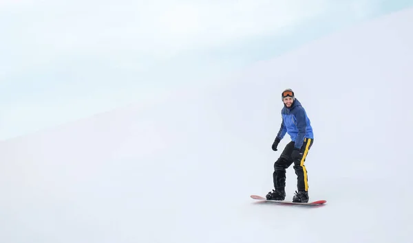 Hombre snowboarder en pendiente en estación de invierno — Foto de Stock