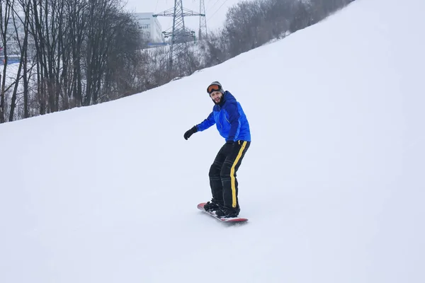 Hombre snowboarder en pendiente en estación de invierno — Foto de Stock